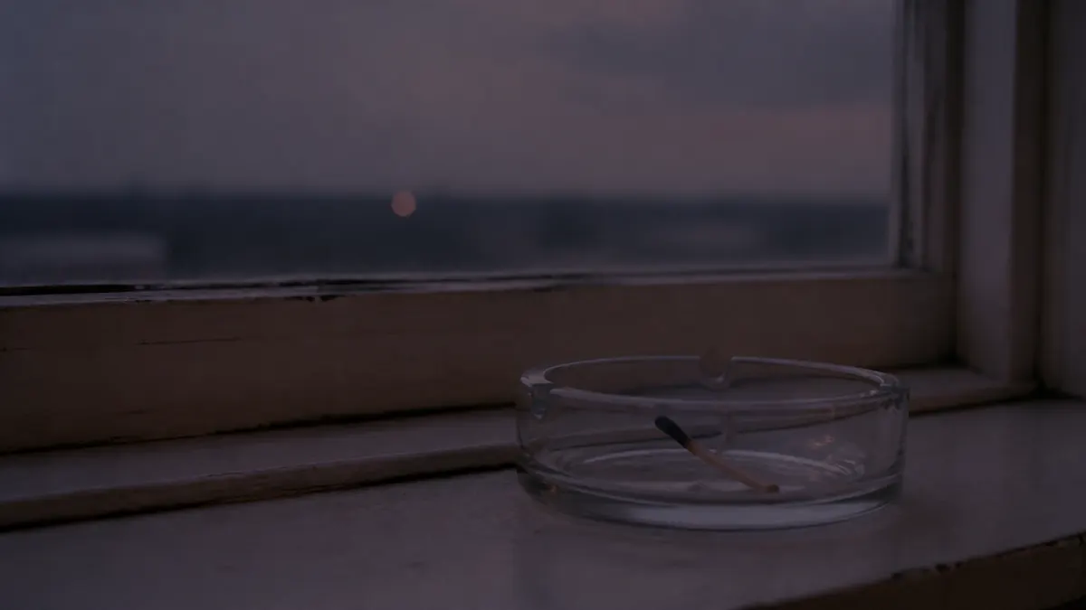 窓辺に置かれた灰皿と夕暮れの街